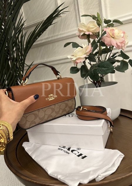 حقيبة يد من ماركة "كوتش" (Coach)، تحديدًا موديل Mini Josie Top Handle  تتميز بتصميم أنيق وعصري، مع مقبض علوي وحزام كتف قابل للتعديل يمكن ارتداؤه على الكتف أو بشكل كروسجودة عالية فل باكج مختومة قاعدةً22 سم