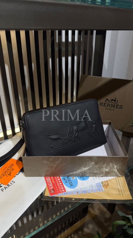 حقيبة يد رجالية (Clutch/Pouch) باللون الأسود، وتتميز بجلد محبب (Pebbled Leather) مع شعار "العربة والحصان" البارز، وهو الرمز الشهير لعلامة هيرميس (Hermès). تتميز بسحاب علوي، وغالباً ما تأتي مع معصم يد جانبي لسهولة الحمل. تظهر بعض النسخ المماثلة في المتاجر الإلكترونية تحت مسمى "Hermes Pouch Unisex" أو "Hermes Leather Men's Clutch".فل باكجً مختومة قاعدة 24 سم
