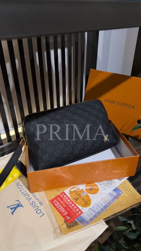 تُعرف هذه الشنطة من ماركة لويس فيتون (Louis Vuitton) باسم "باوتش" (Pouch) أو "حقيبة يد" (Handbag)، وتحديداً ضمن تشكيلة Pochette Voyage.تفاصيل الشنطة:الموديل: تتميز بنمط المربعات الشهير الخاص بالماركة والمعروف باسم Damier، وتحديداً بلون Damier Graphite (الأسود والرمادي الداكن).الخامة: عادة ما تكون مصنوعة من جلد البقر الفاخر أو الكانفاس المطلي.الاستخدام: تُستخدم كحقيبة يد صغيرة لحمل المستلزمات الشخصية مثل الهاتف، المحفظة، والمفاتيح، وتأتي أحياناً مع حزام معصم جلدي.فل باكج مختومة قاعدة 24 سم