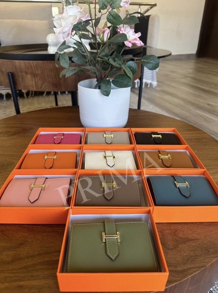 محفظة Hermès Bearn Min تتميز المحفظة بتصميمها الأنيق والمدمج، وهي مصنوعة من الجلد مع قفل مميز على شكل حرف "H" باللون الذهبي. تحتوي من الداخل على عدة فتحات للبطاقات الائتمانية .وجيب بسحاب للعملات المعدنية وجيب للأوراق الورقية.مختومة فل باكج