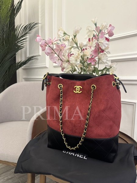 حقيبة يد دلو من شانيل. الحقيبة مصنوعة من مزيج من جلد الغزال (الشمواه) وجلد أسود مبطن في الجزء السفلي. التصميم: تتميز بشكل دلو مع حزام علوي قصير وحمالات سلسلة متشابكة باللون الذهبي مع شريط جلدي.مختومة وجودة عالية قاعدة 29 سم وارتفاع 33 سم