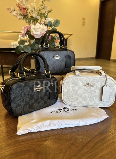 حقيبة يد صغيرة من كوتش  مستطيلة الشكل مع مقابض علوية قصيرة وحزام كتف قابل للإزالة. تتميز الحقائب بنقشة شعار "كوتش" المتكرر.مختومة فل باكج قادة 19 سم